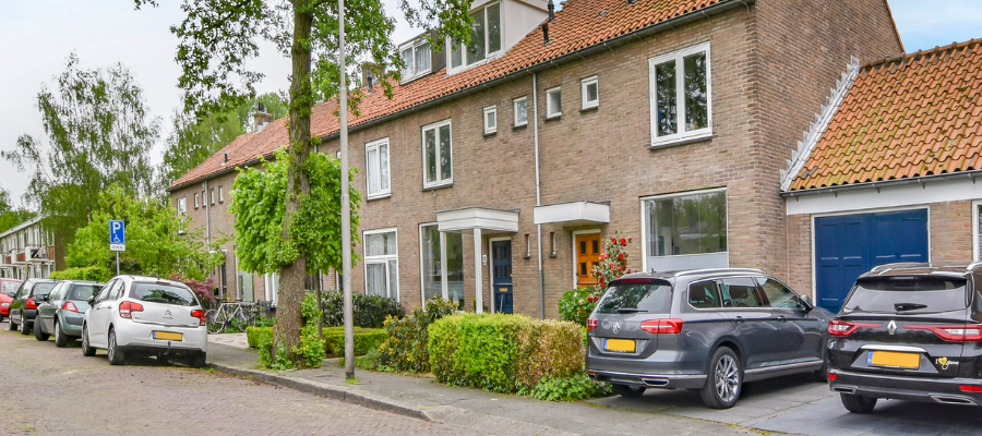 Residential street lined with parked cars. 